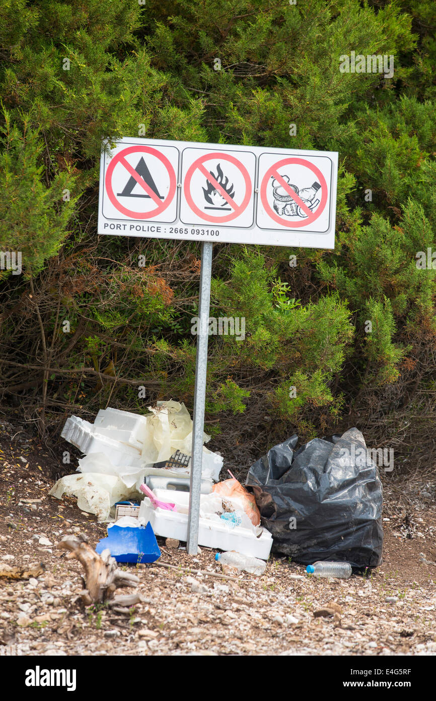 The irony of litter being left below a no litter sign in Sivota, Greece. Stock Photo