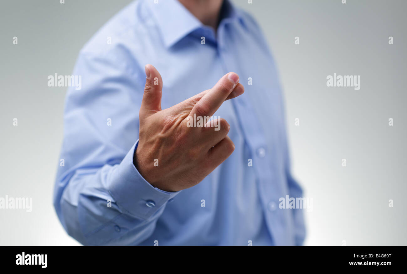 Businessman with fingers crossed Stock Photo