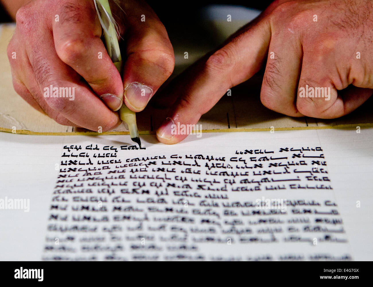 Torah writer rabbi Reuven Yaacobov works on a Torah at the Jewish Museum in Berlin, Germany, 10 July 2014. The installation 'bios [torah]' by artist group robotlab is on display until 01 January 2015. Photo: DANIEL BOCKWOLDT/dpa Stock Photo