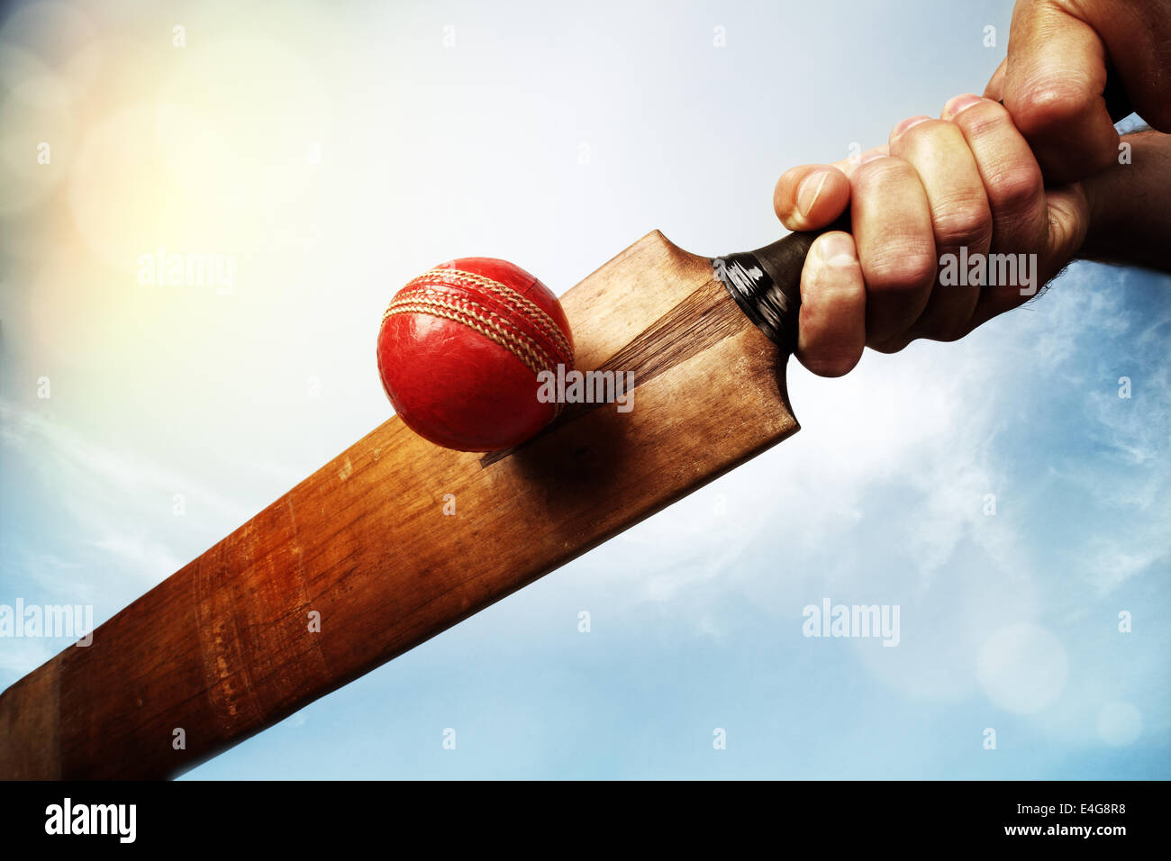 Cricket player hitting ball Stock Photo