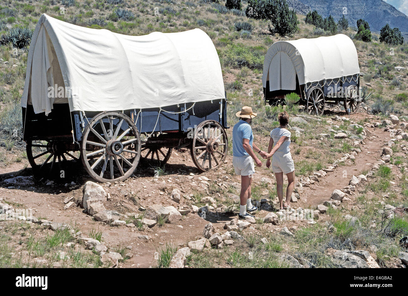 An adventurous couple heads for the covered wagon that is their unusual bedroom lodging at Bar 10 Ranch high above the Grand Canyon in Arizona, USA. Stock Photo