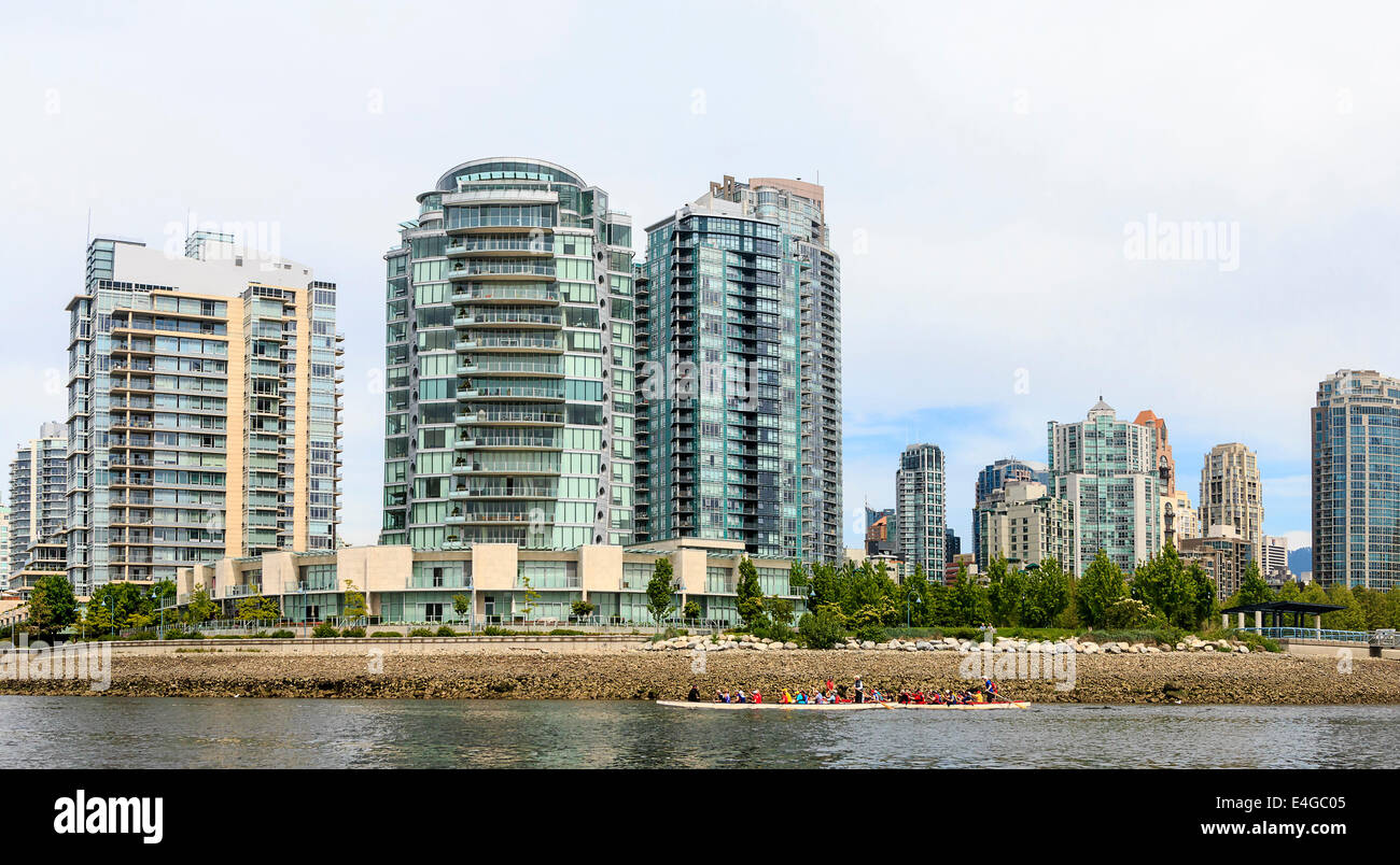 City skyline of Vancouver, British Columbia, Canada, as seen from the water. Famous curved building is in view along with kayaks Stock Photo