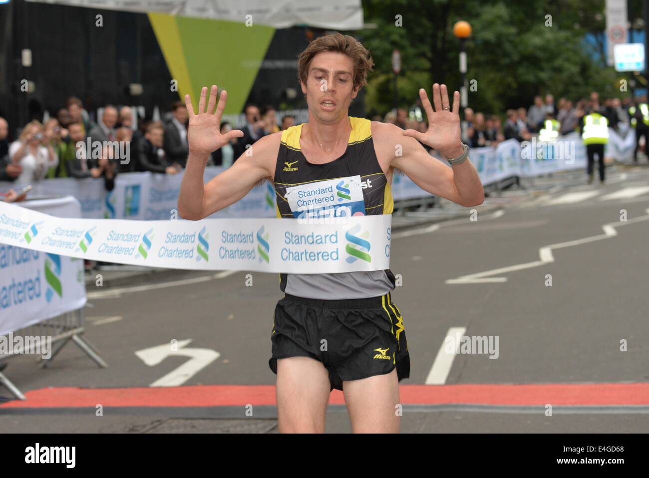 London, UK. 10th July, 2014. Phil Wicks is the first male runner at the finish and is has 6th years wins at the Standard Chartered Great City Race 2014 in London. Credit:  See Li/Alamy Live News Stock Photo