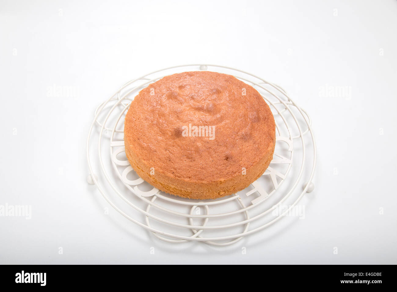 Sponge Cake Rack Victoria sponge cake set on a round cooling rack on a light background ...