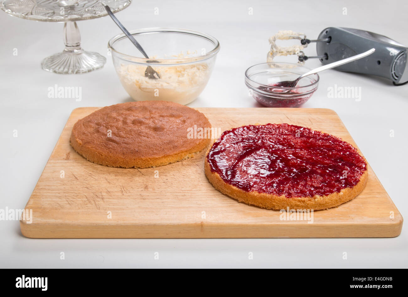 a victoria sponge cake sliced, jam spread,ready for butter cream  [Land] 'making a cake' (28 of 44) Stock Photo