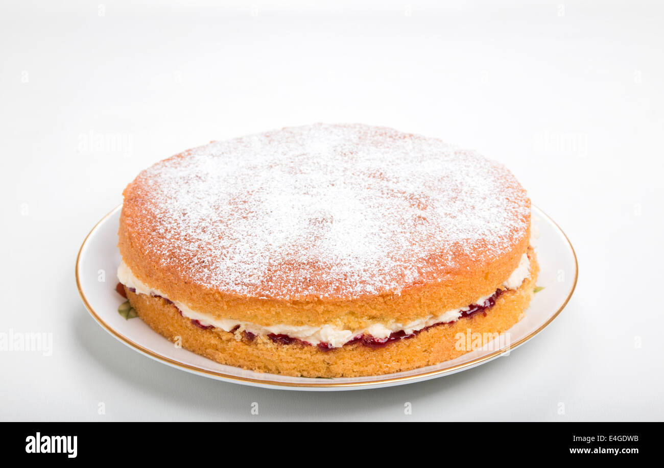 victoria sponge cake Filled with jam and butter cream sprinkled with icing sugar on a plate   'cut out'(39 of 44) Stock Photo