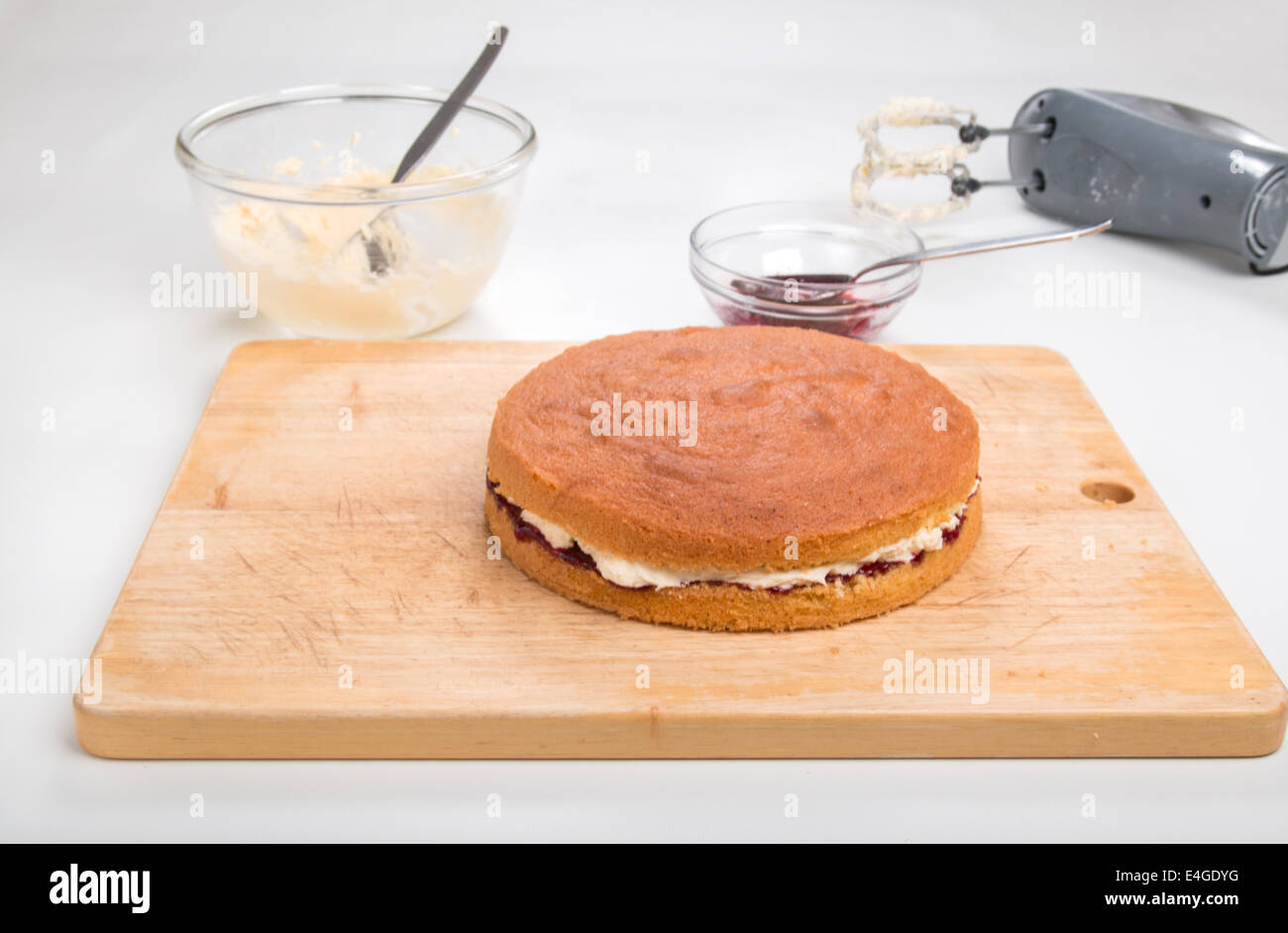 victoria sponge Filled with jam and butter cream on a wooden board  [Land] 'making a cake' (33 of 44) Stock Photo