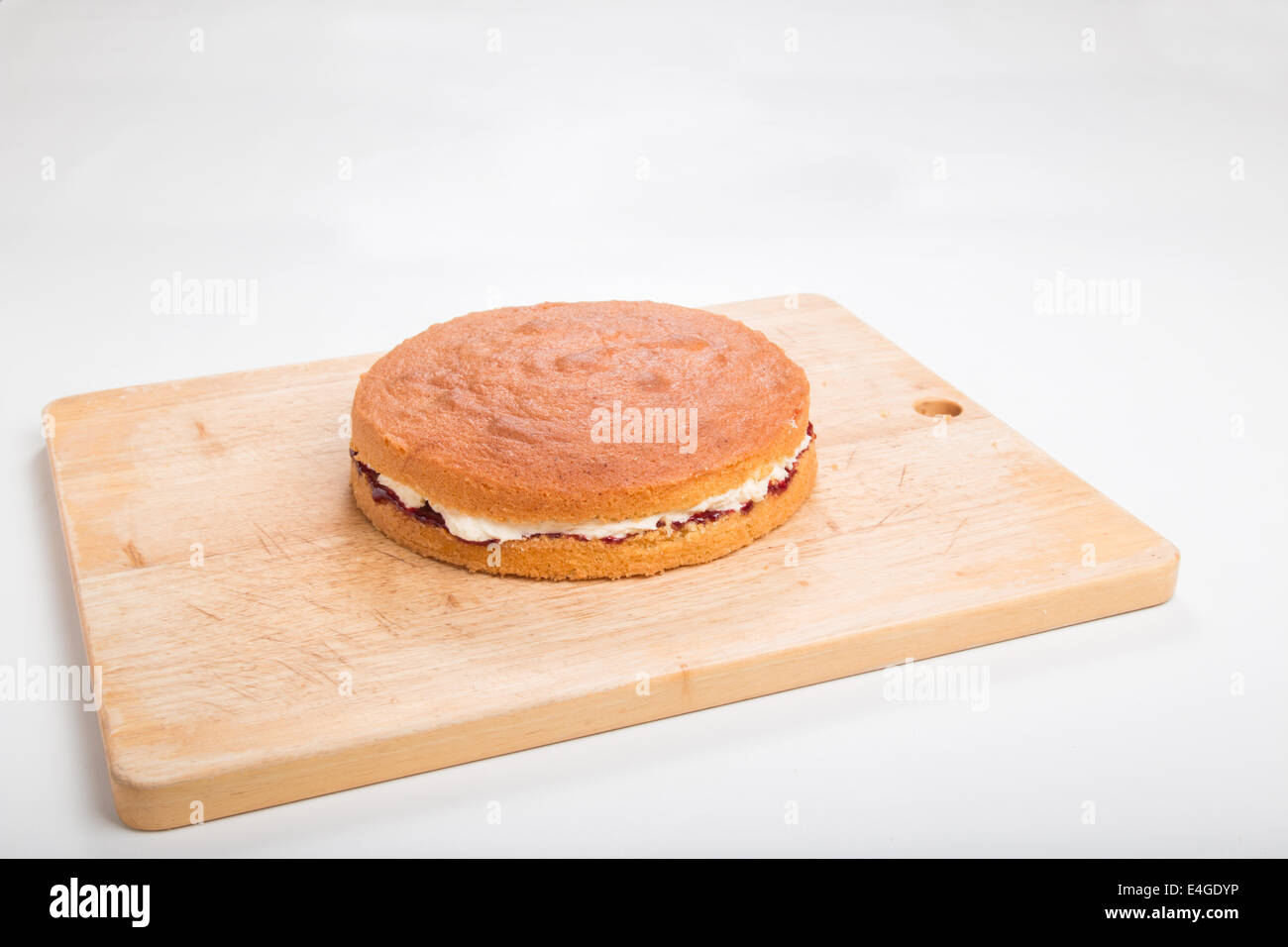 victoria sponge cake Filled with jam and butter cream on a wooden board  [CO] [Land] 'making a cake' (36 of 44) Stock Photo