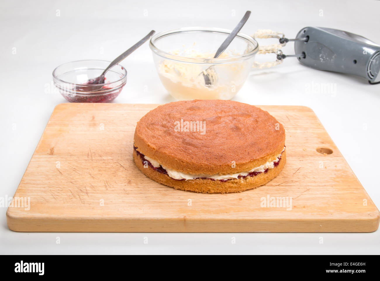 victoria sponge cake Filled with jam and butter cream on a wooden board  [Land] 'making a cake' (34 of 44) Stock Photo
