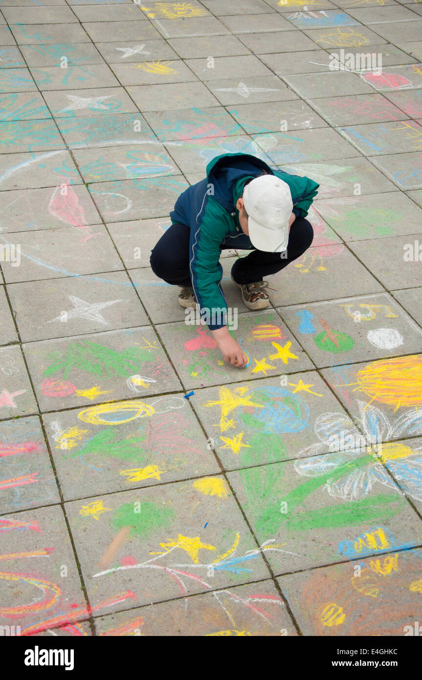 A boy paints chalk on the pavement Stock Photo - Alamy