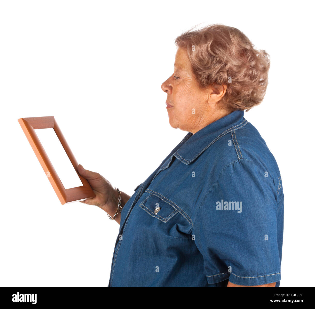 Old lady crying watching a blank photo frame on white. Stock Photo