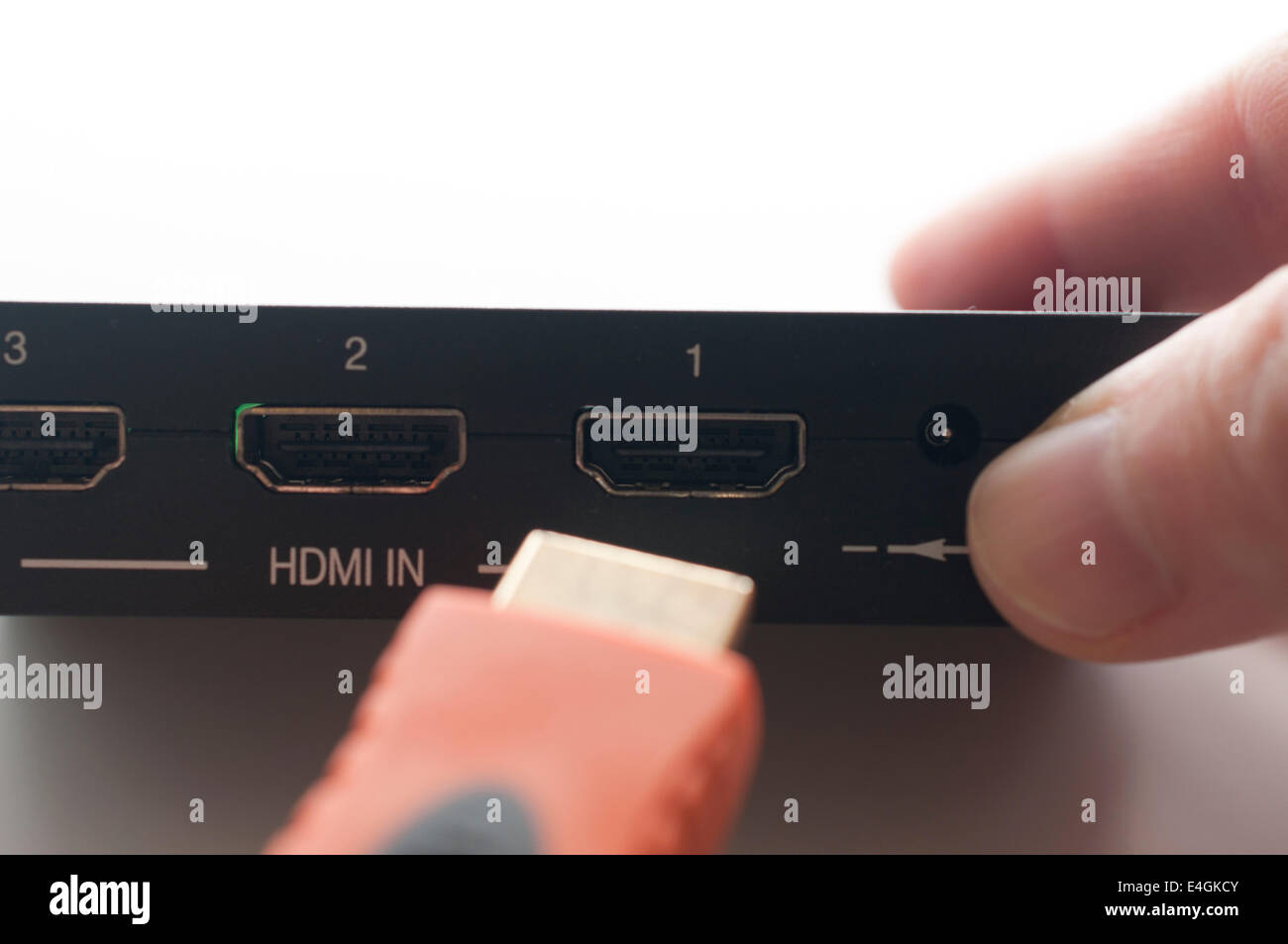 Hand holding hdmi cable to plug in of device Stock Photo
