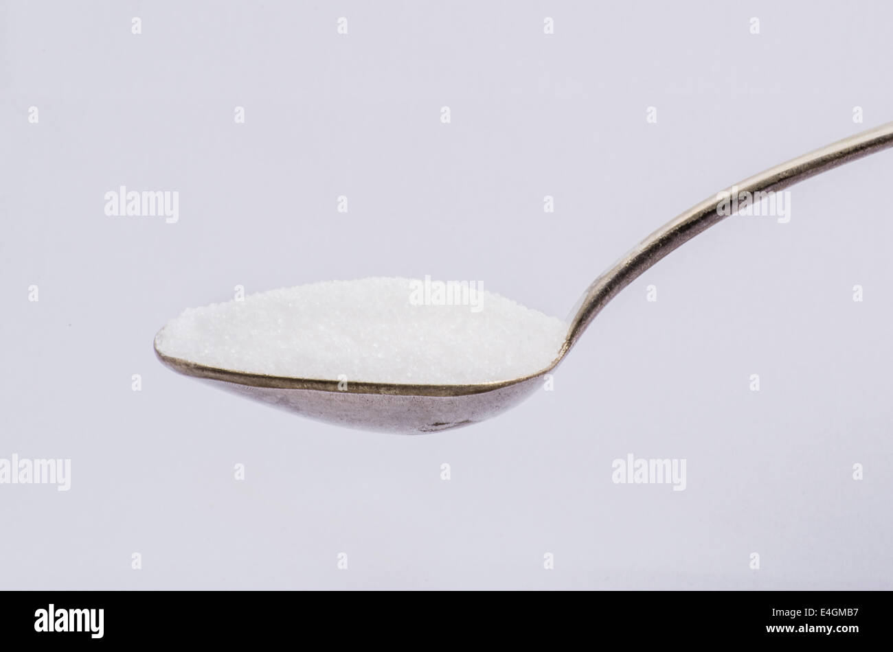 Heaped tea spoon full of white sugar Stock Photo