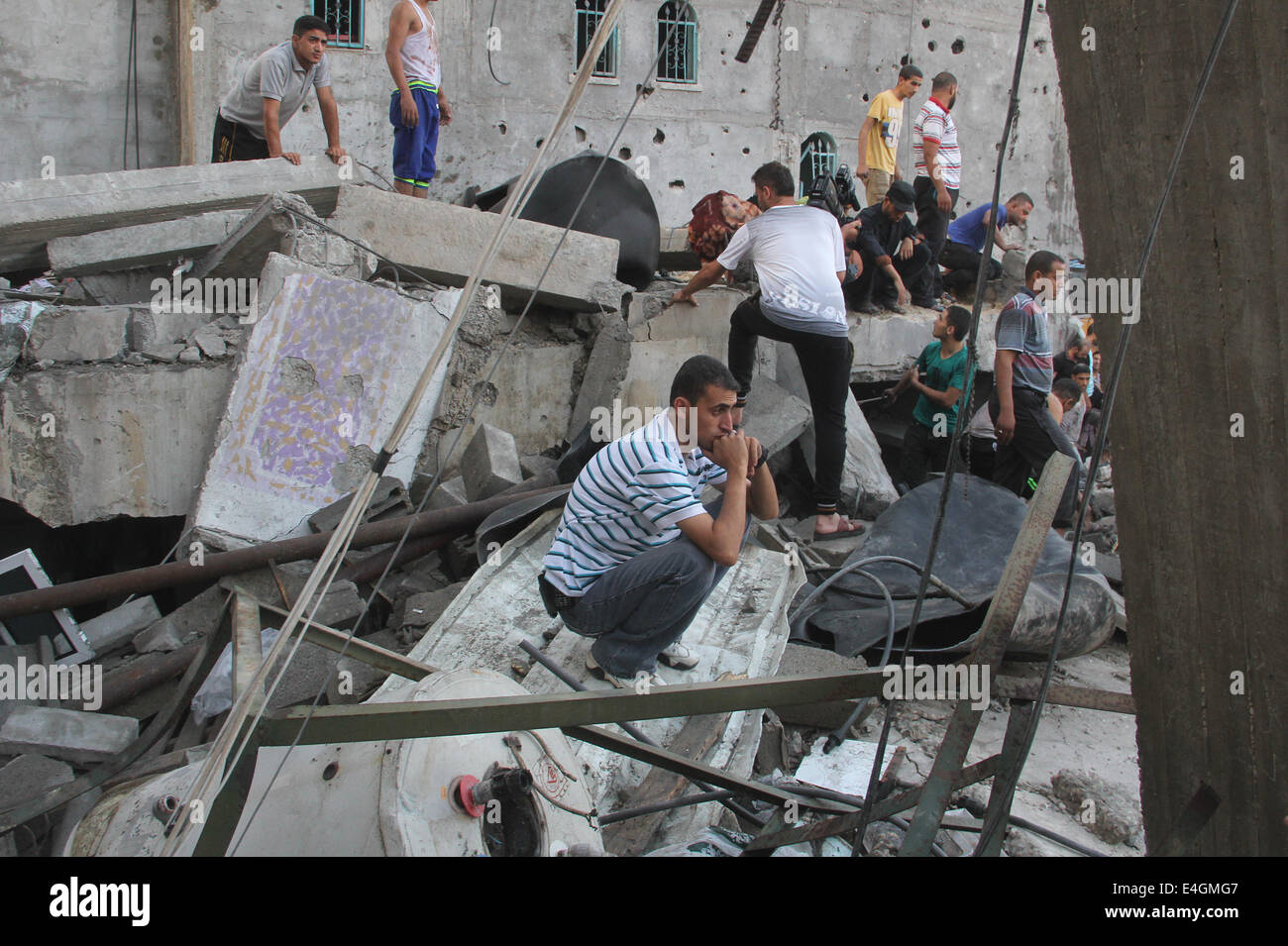Gaza. 11th July, 2014. Palestinians inspect the rubble of a building after it was targeted in an Israeli airstrike early on July 11, 2014, in the southern Gaza strip city of Rafah. At least 88 Palestinians were killed and 660 injured over the past three days, according to Gaza medical officials. Credit:  Khaled Omar/Xinhua/Alamy Live News Stock Photo