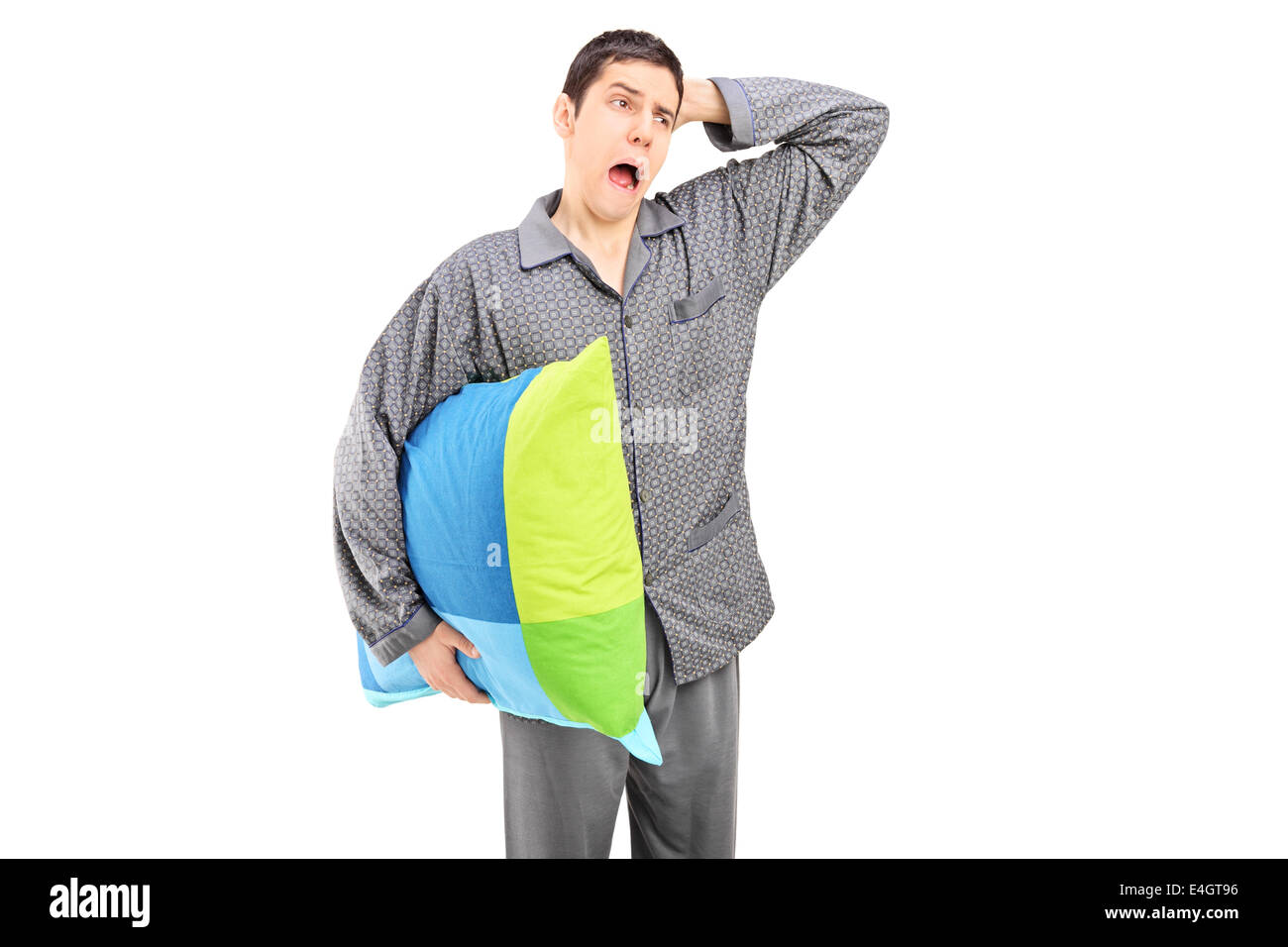 Yawning man in pajamas holding a pillow Stock Photo Alamy