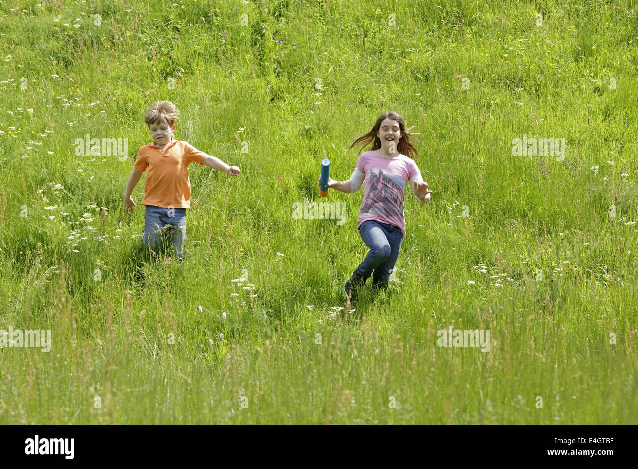 two children running down a meadow Stock Photo