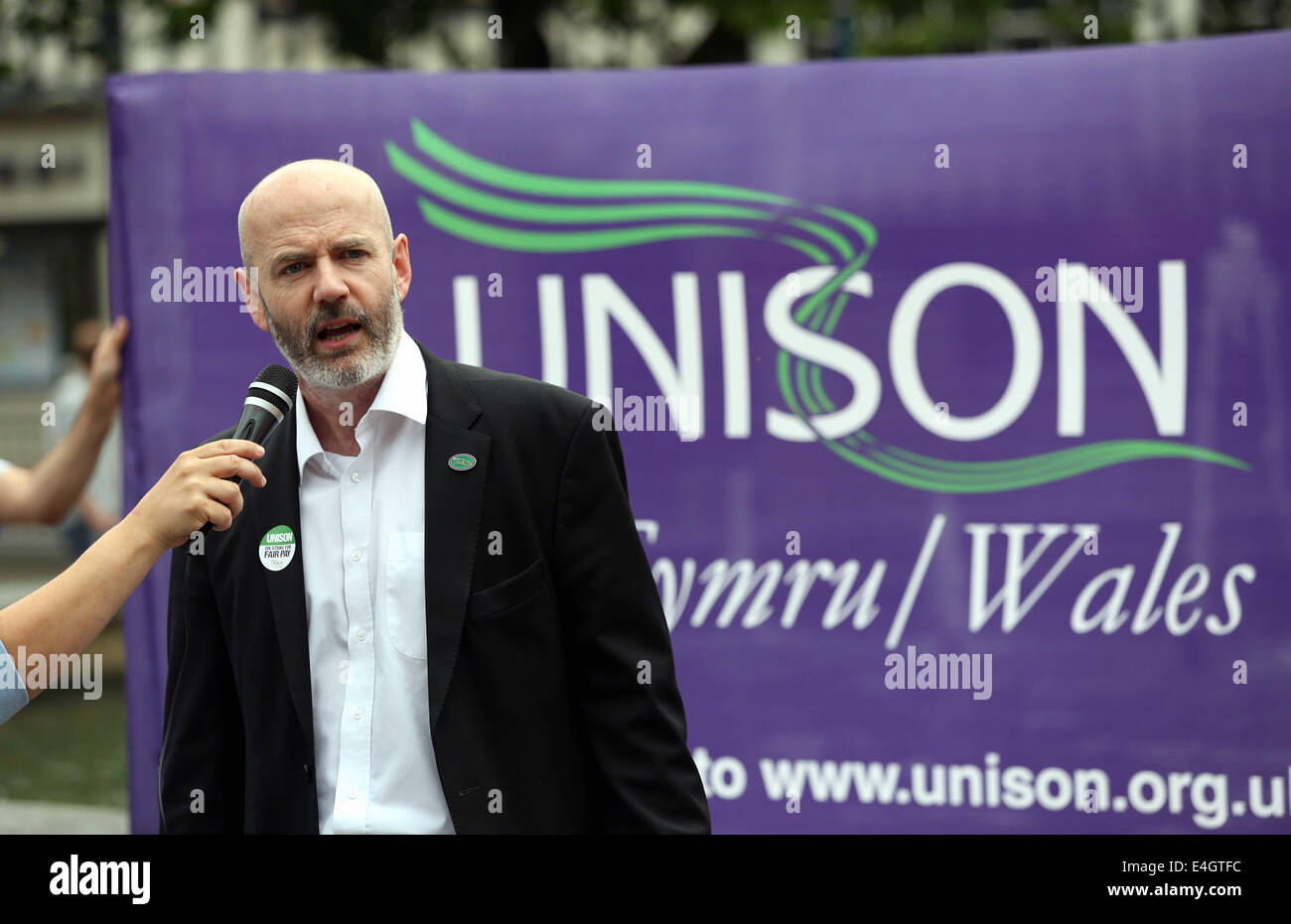 Swansea, UK. 10th July, 2014.  Pictured: Dominic MacAskill of Unison speaking at Castle Square Gardens, Swansea, south Wales.  Re: Strikes are taking place across the UK in a series of disputes with the government over pay, pensions and cuts, with more than a million public sector workers expected to join the action.  Firefighters, librarians and council staff are among those taking part from several trade unions, with rallies taking place across the UK. Credit:  D Legakis/Alamy Live News Stock Photo