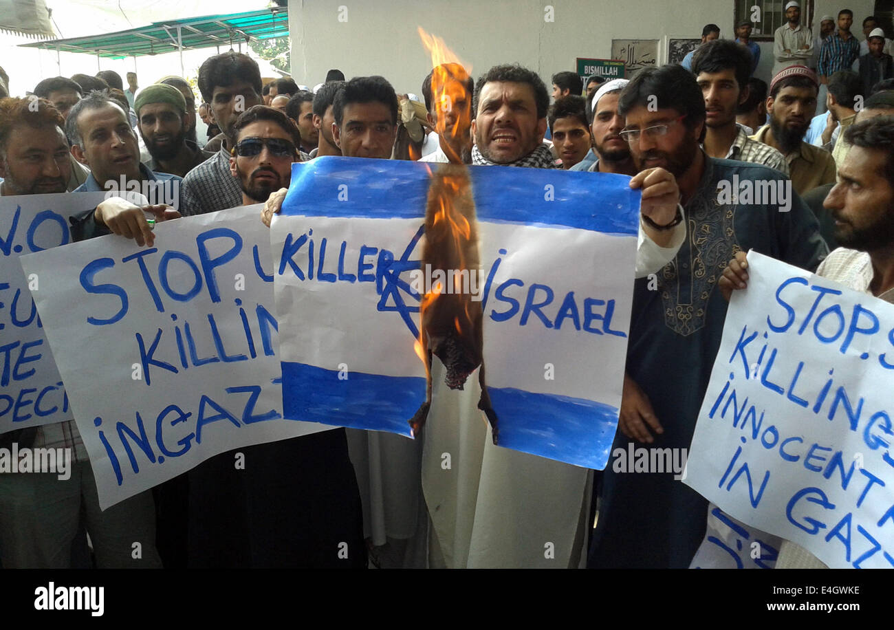 Srinagar, Indian Administered Kashmir. 11 July 2014 : Kashmri people shout anti-Israel slogans and  burn Israel flag  after friday prayers  during a protest against Israeli military operations in Gaza, Muslims in revolt-hit Indian Kashmir held noisy demonstrations in and outside mosques to protest Israeli raids in Gaza Credit:  Sofi Suhail/Alamy Live News Stock Photo