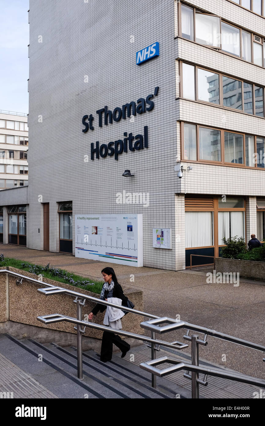 A woman walks up steps outside St St. Saint Thomas' Thomas Thomas's Hospital, London, UK Stock Photo