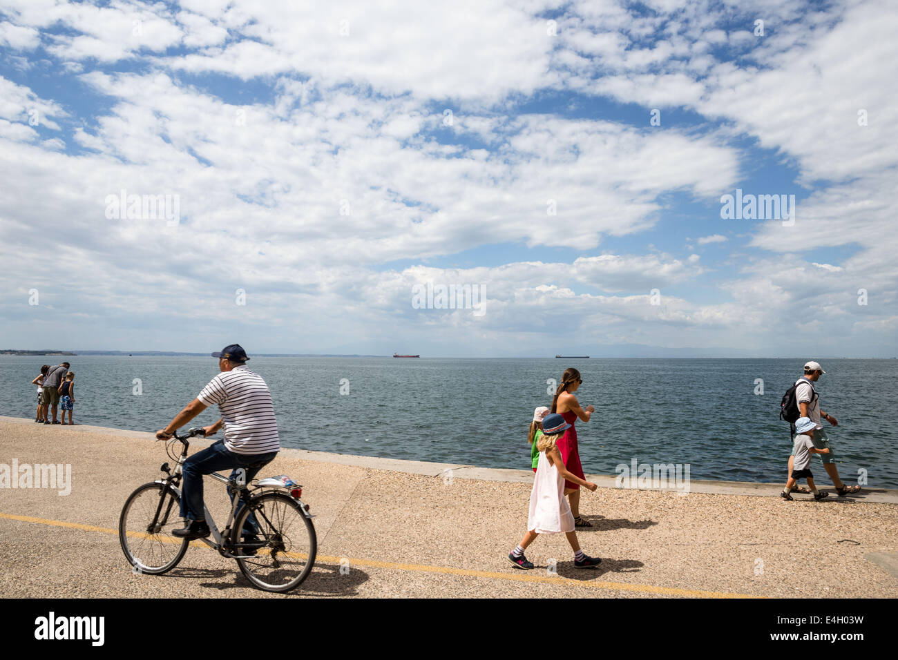 Thessaloniki, Greece. 11th July 2014. Tourists walk at the seafront of Thessaloniki, Greece. The Association of Greek Tourism Enterprises (SETE) increased its estimate for international tourist arrivals in 2014 to 19 million from 18.5 million last year. Thessaloniki, Greece on July 11, 2014. Credit:  Konstantinos Tsakalidis/Alamy Live News Stock Photo