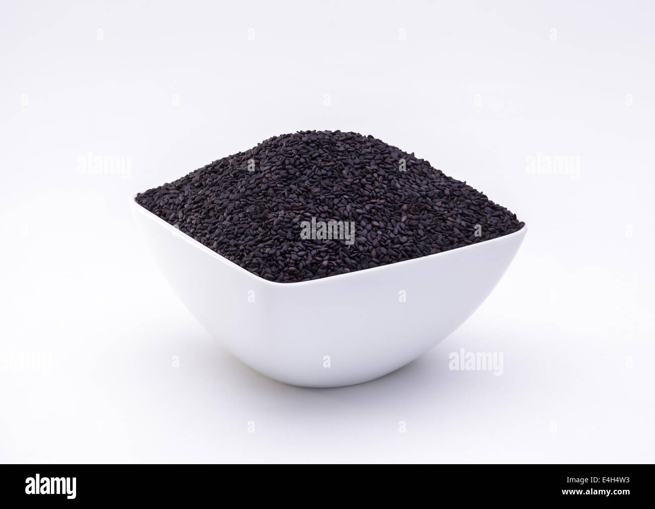 Black sesame seeds in the bowl isolated on white background Stock Photo