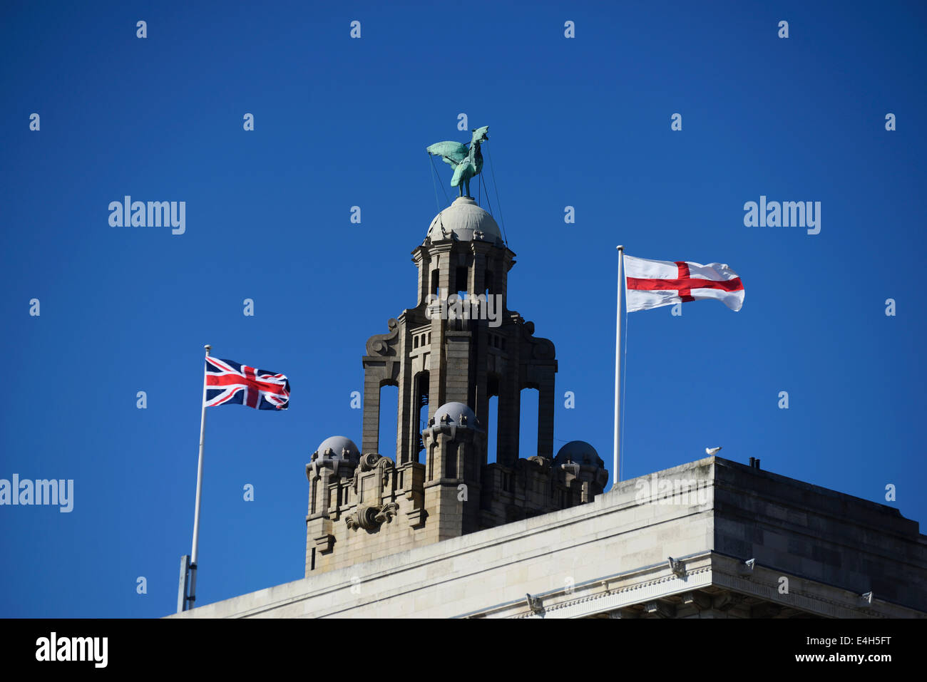 Liverbird on top of the Royal Liver Building at Pier Head, Liverpool with british flags blowing in the wind. Stock Photo