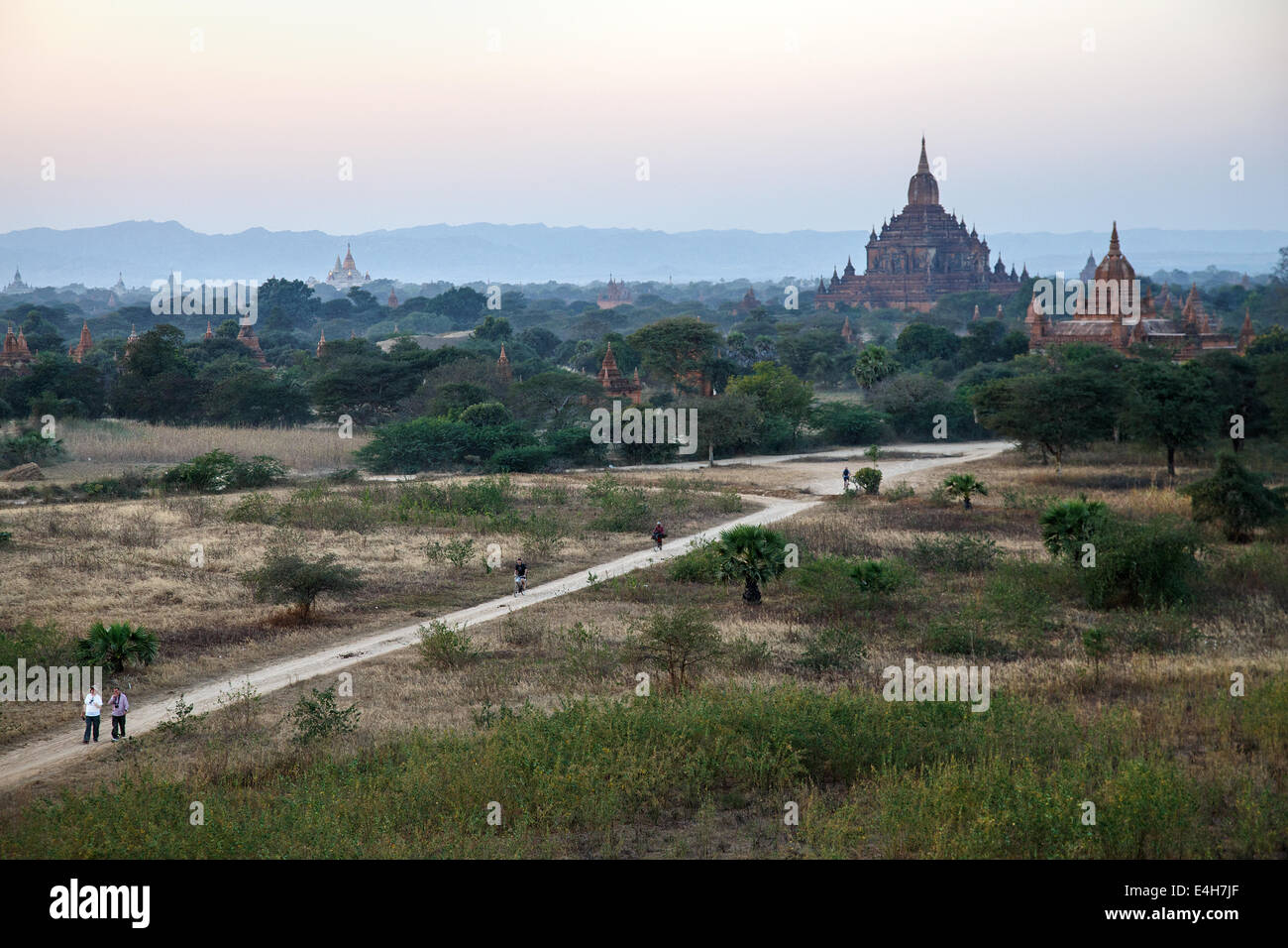 A view onto Bagan temples with tourists on the dirt road, Myanmar. Stock Photo