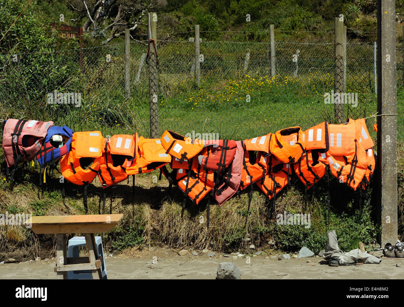Life jackets for tourists visiting the penguin colony hang out to dry on the beach at Puñihuil. Puñihuil, Isla Grande de Chiloe, Stock Photo