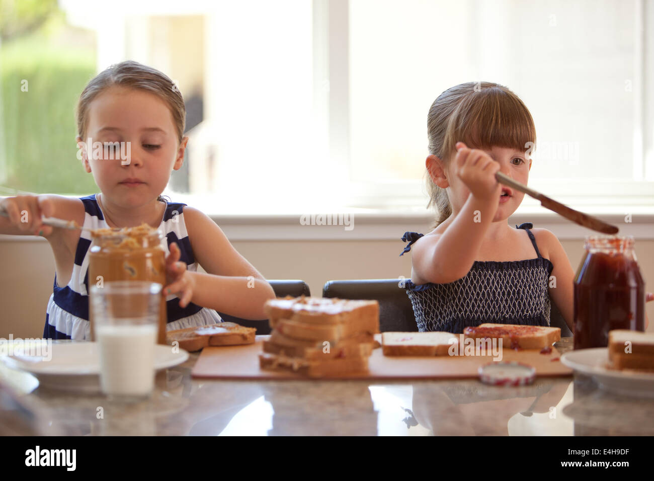 Girls making peanut butter and jelly sandwiches Stock Photo Alamy