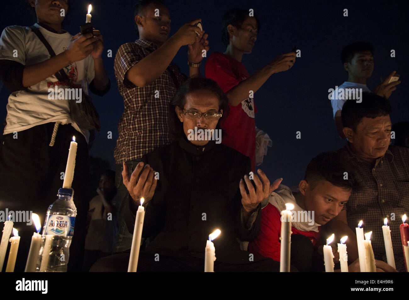 Jakarta, Jakarta, Indonesia. 11th July, 2014. A man pray with his heart to support palestine. Hundreds of Jokowi supporters gathered at Indonesia Proclamation Monument to lit 1000 candle in supporting the people of palestine that was bombed by Israel Milliter at Gaza. Credit:  Donal Husni/NurPhoto/ZUMA Wire/Alamy Live News Stock Photo