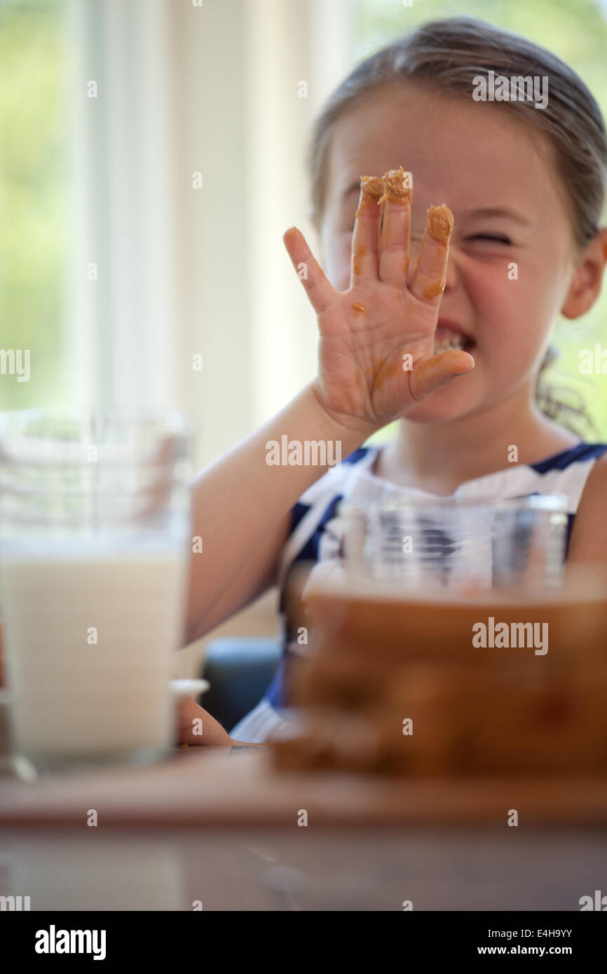Girl smiling with peanut butter on fingers Stock Photo Alamy