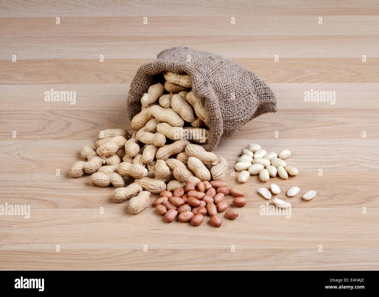 Peanuts in the bag sack isolated on wooden table Stock Photo