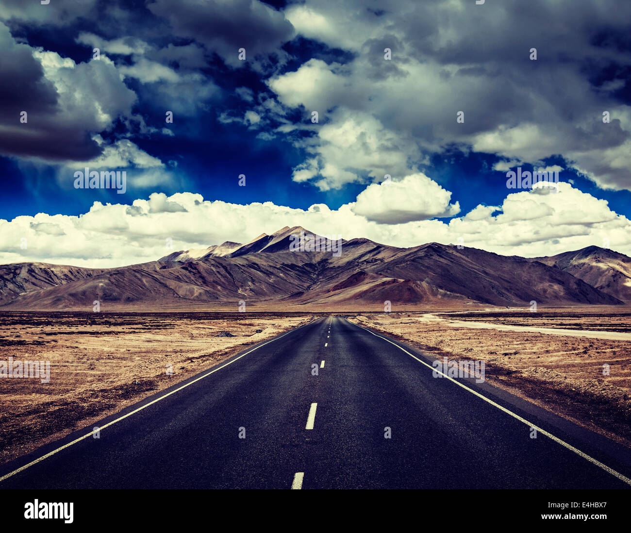 Vintage retro effect filtered hipster style travel image of Travel forward concept background - road on plains in Himalayas Stock Photo