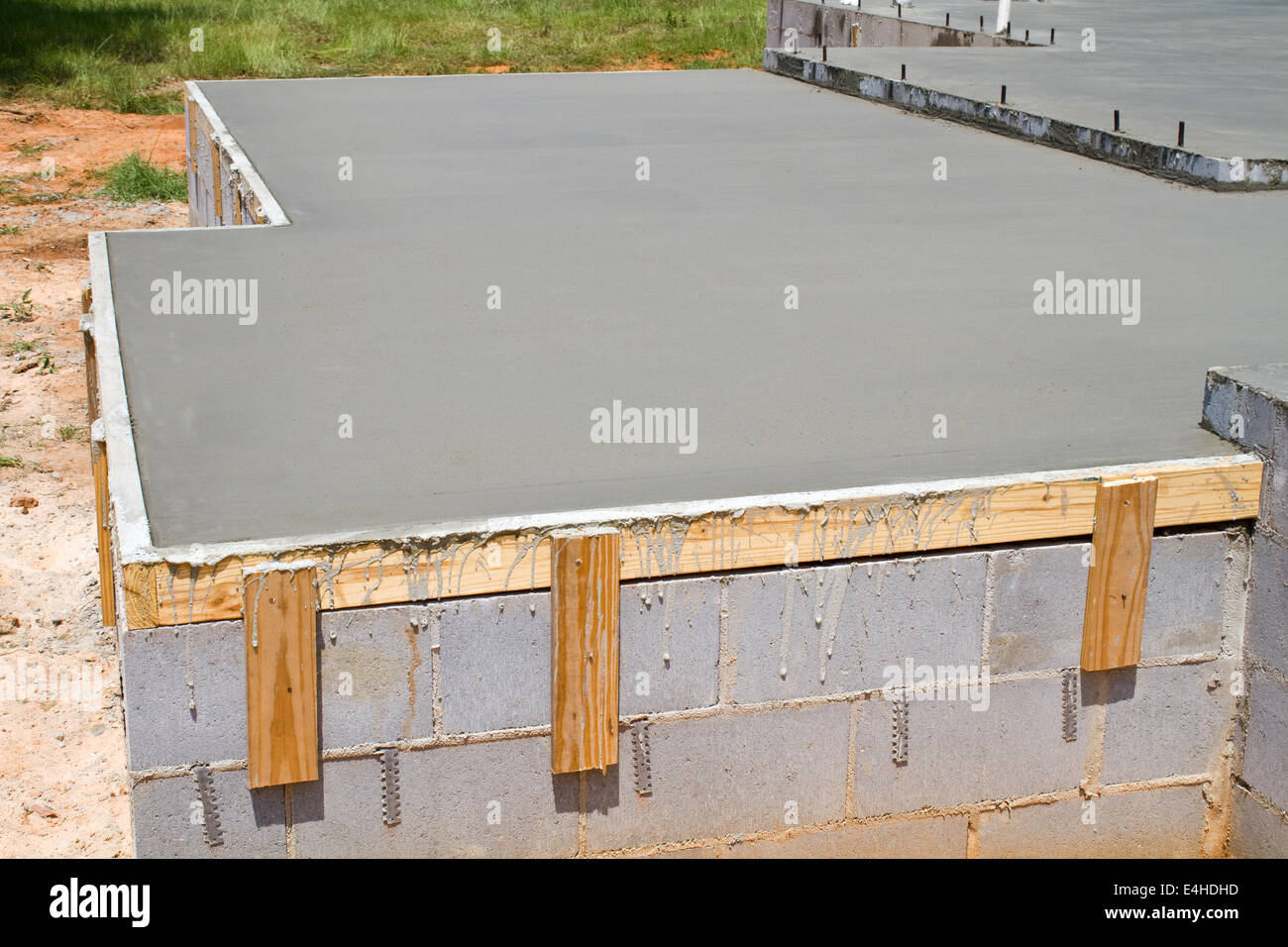 New construction of a freshly poured concrete slab floor on a residential home cures and hardens. Stock Photo