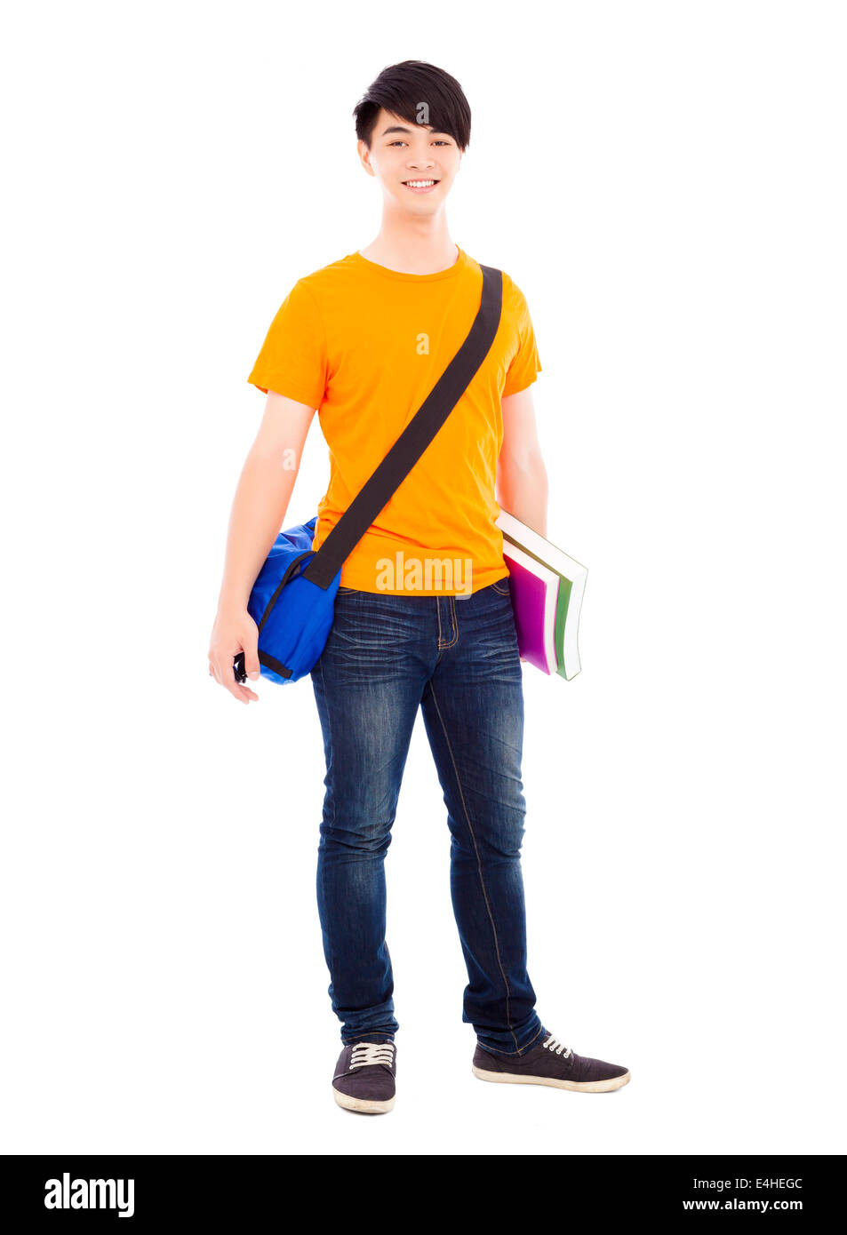smiling young student standing and holding books Stock Photo - Alamy
