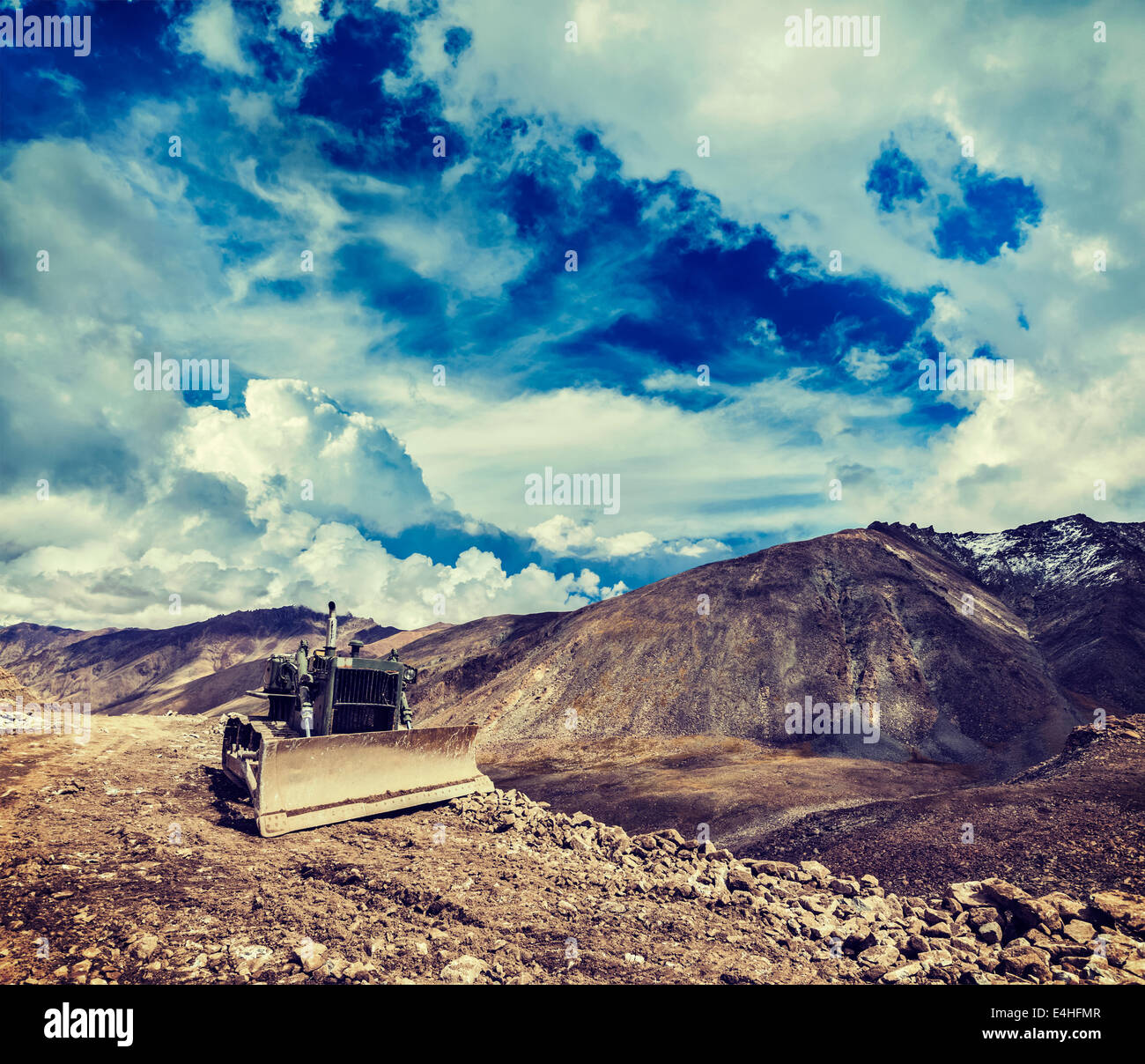 Vintage retro effect filtered hipster style travel image of Bulldozer on road in Himalayas. Ladakh, Jammu and Kashmir, India Stock Photo