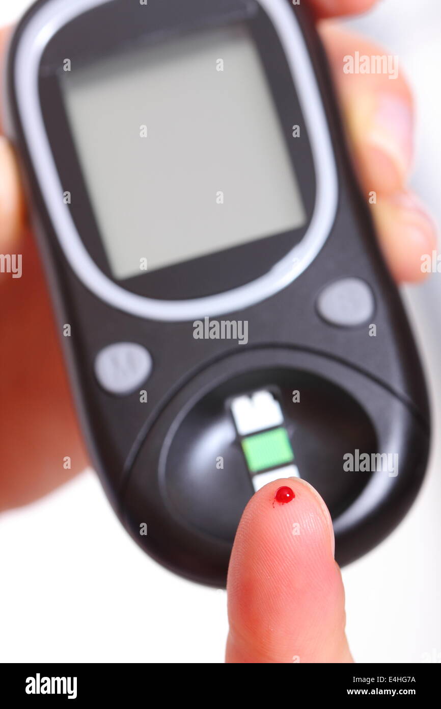 Closeup of finger with blood and glucose meter, taking blood sample