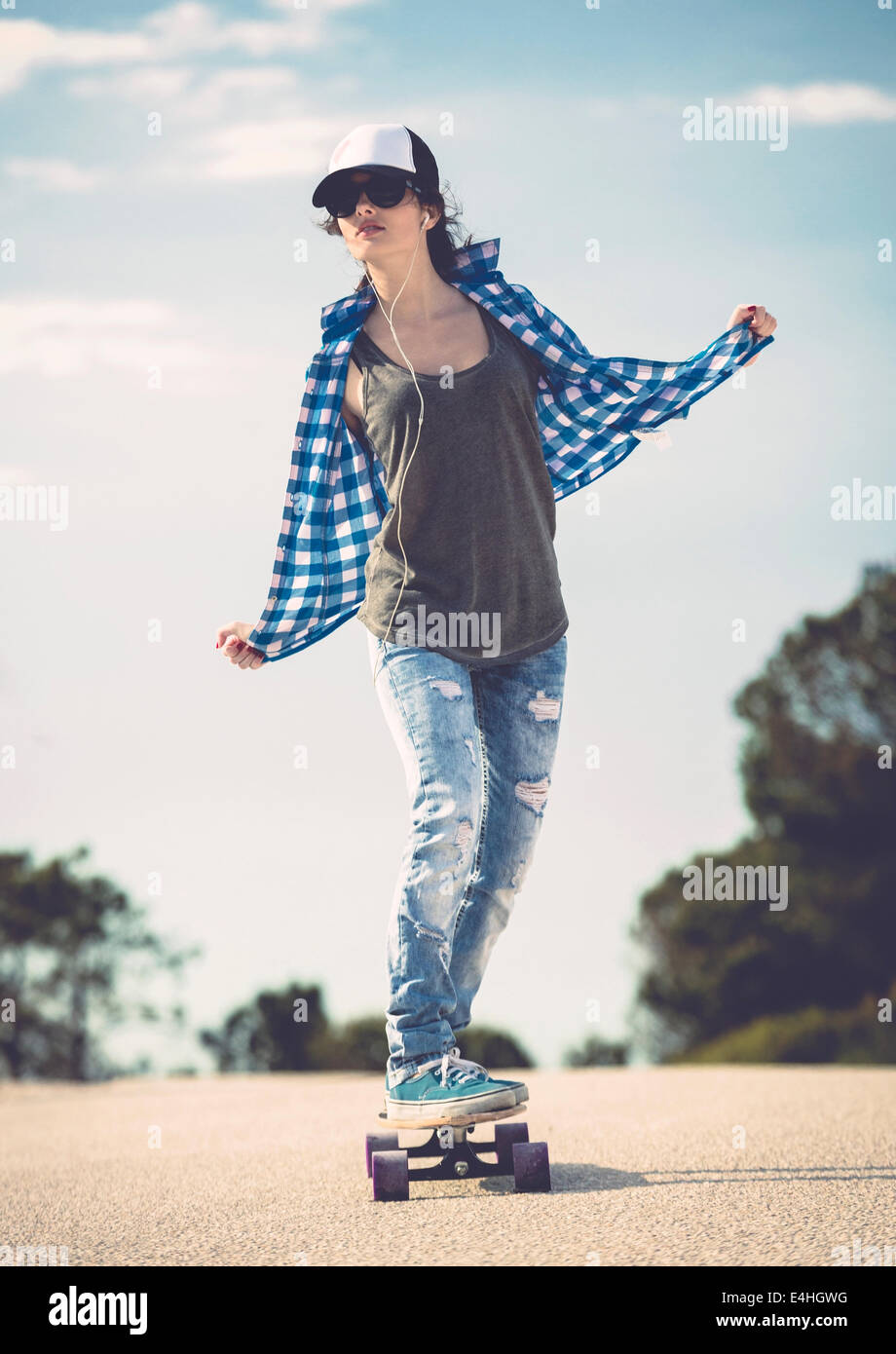 Young woman down the road with a skateboard Stock Photo
