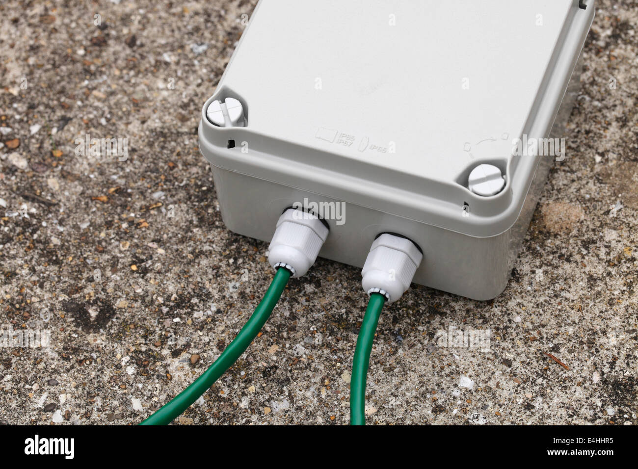 Weatherproof IP67 terminal box with cable glands and green CAT5e network cable Stock Photo