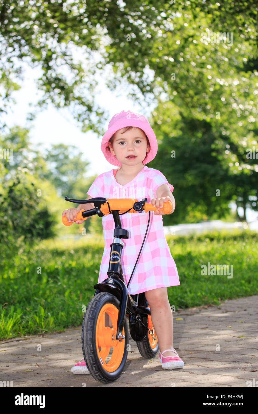 little girl cycling in a park Stock Photo