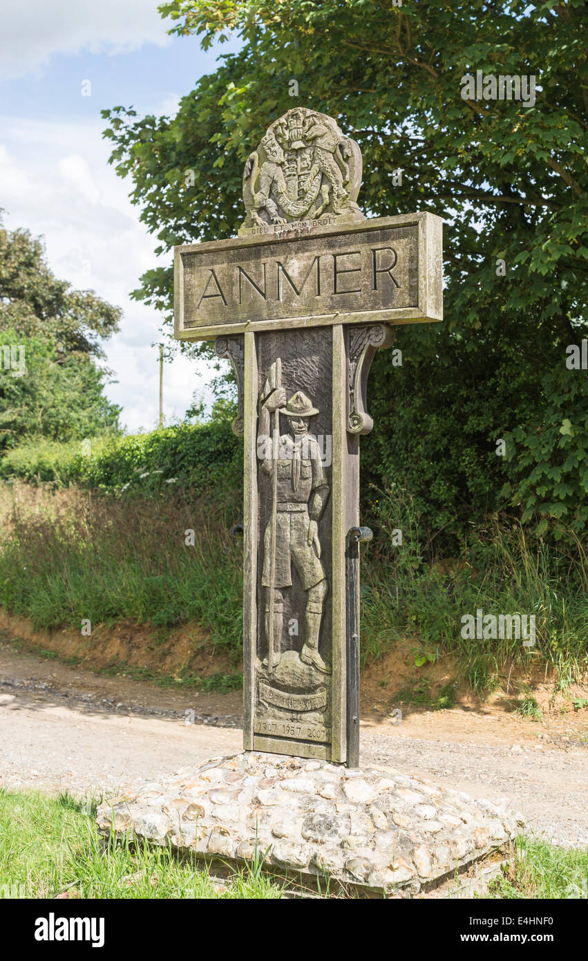 Wooden name sign of the village of Anmer, near Sandringham, Norfolk, UK, with carved boy scout and 'Be Prepared' scouting movement inscription logo Stock Photo