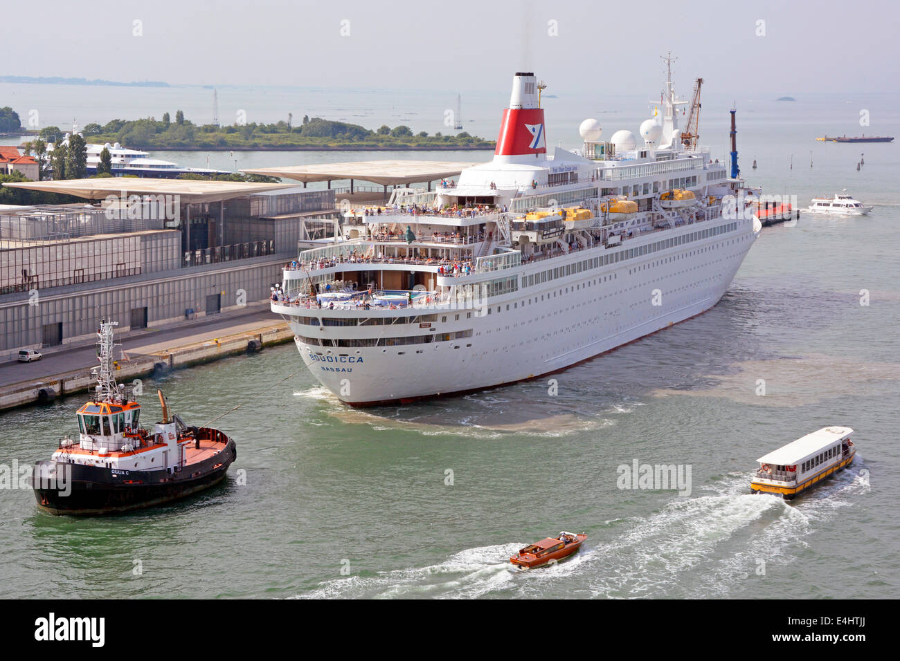 Passengers On Deck Of Fred Olsen Lines Cruise Ship Liner Boudicca Being Towed Backwards By Tugboat To Birth For Summer Visit To Port Of Venice Italy Stock Photo Alamy