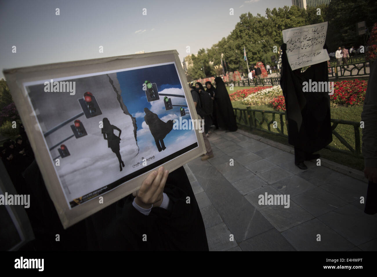Tehran, Iran. 12th July, 2014. July 12, 2014 - Tehran, Iran - Iranian veiled women hold placards as they take part a rally to support of Hijab (Islamic Dressing Code) in Mellat (Nation) Park in northern Tehran. Morteza Nikoubazl/ZUMAPRESS Credit:  Morteza Nikoubazl/ZUMA Wire/Alamy Live News Stock Photo