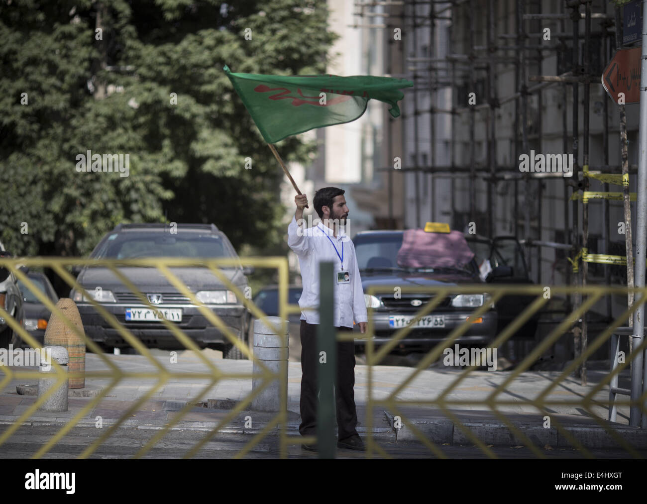 Tehran, Iran. 12th July, 2014. July 12, 2014 - Tehran, Iran - An Iranian man waves a religious flag during a rally to support of Hijab (Islamic Dressing Code) in Mellat (Nation) park in northern Tehran. Morteza Nikoubazl/ZUMAPRESS Credit:  Morteza Nikoubazl/ZUMA Wire/Alamy Live News Stock Photo