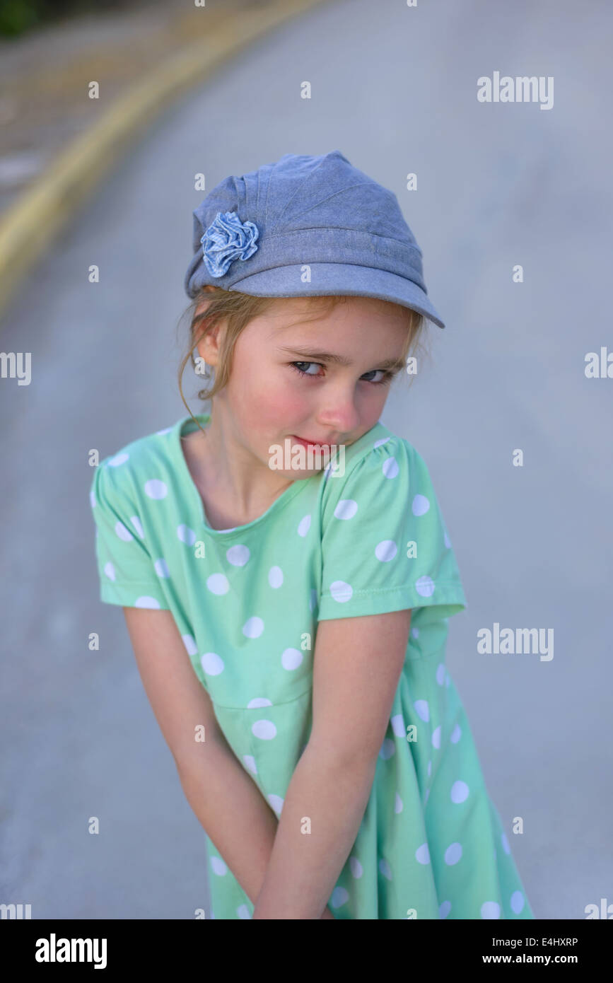 Blonde young kid in denim cap and dress Stock Photo Alamy
