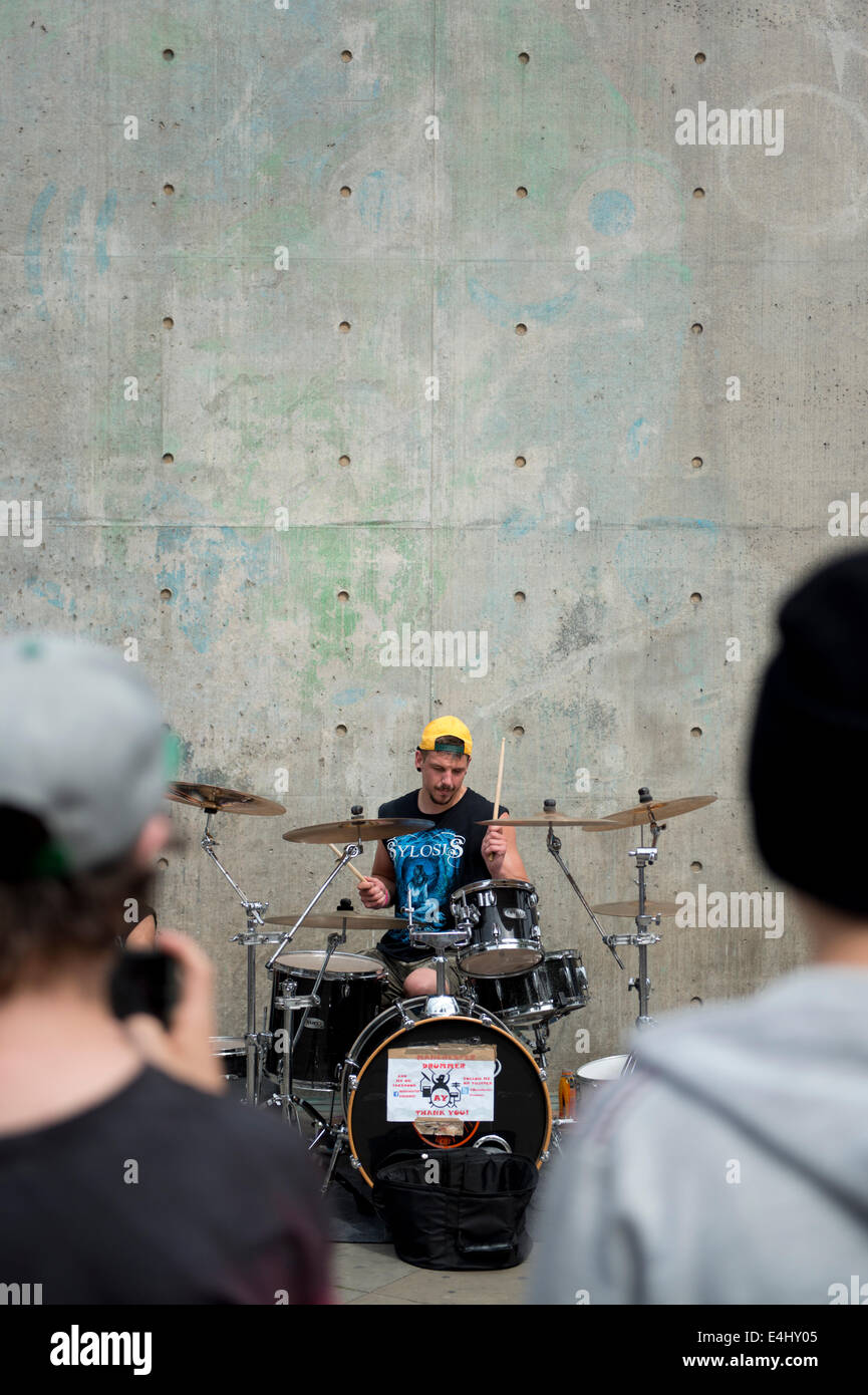 A drummer street performer plays to an audience in the Piccadilly Gardens area of Manchester City Centre. Stock Photo