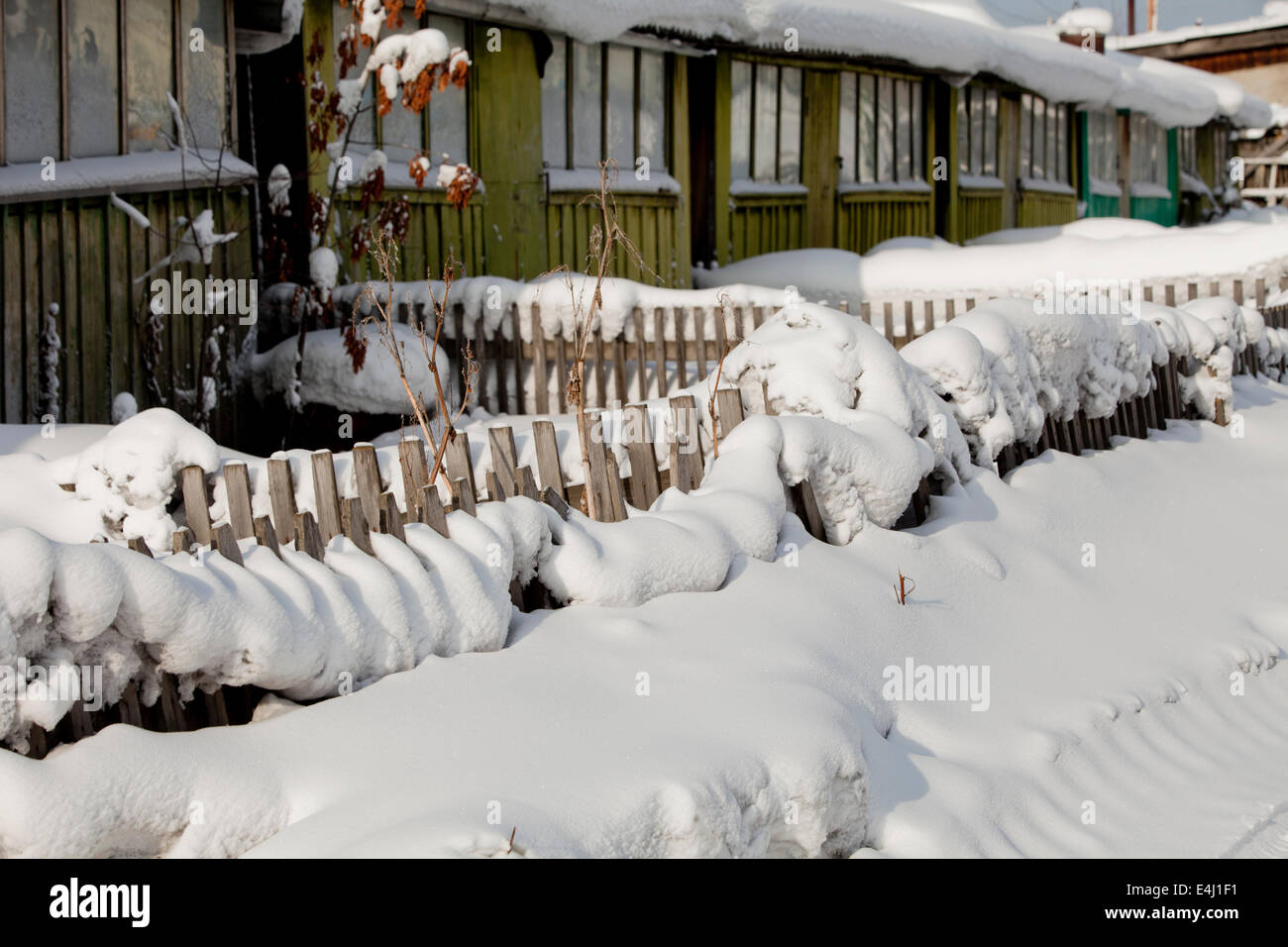 Wooden houses covered in snow picket fence garden Stock Photo
