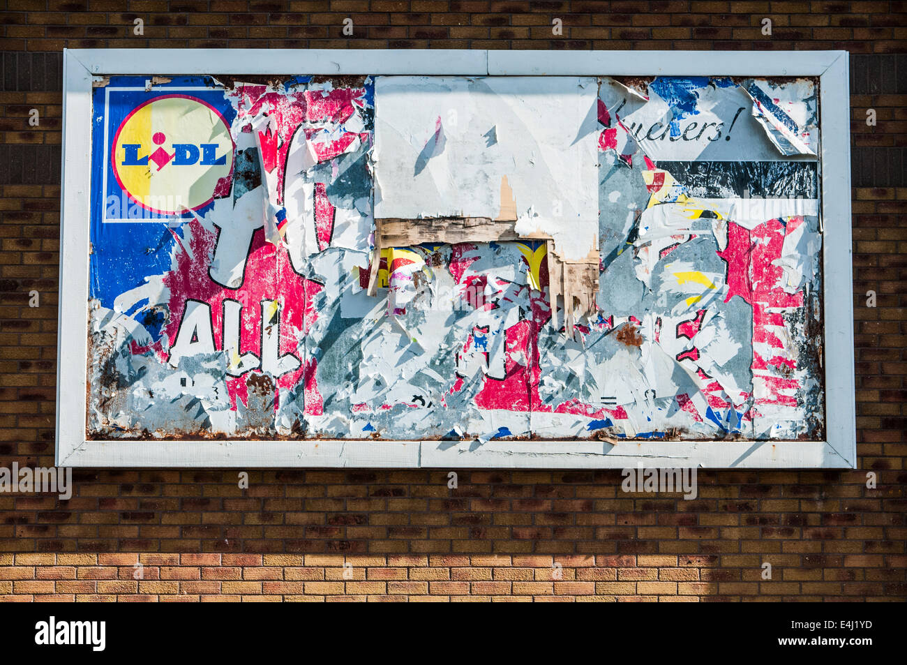 A tattered advertising billboard with an advert for Lidl Stock Photo