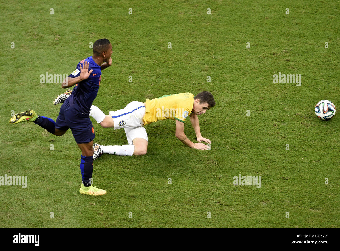 Brasilia, Brazil. 12th July, 2014. Brazil's Oscar (R) falls as vying with Netherlands' Jonathan De Guzman during the third place play-off match between Brazil and Netherlands of 2014 FIFA World Cup at the Estadio Nacional Stadium in Brasilia, Brazil, on July 12, 2014. Credit:  Lui Siu Wai/Xinhua/Alamy Live News Stock Photo