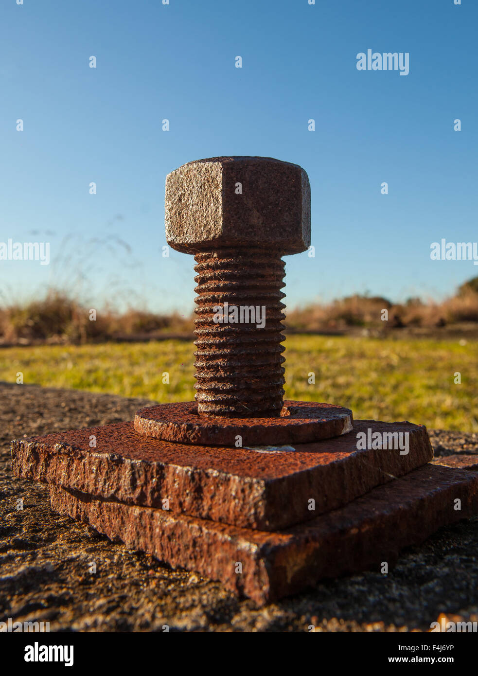 A close-up of a rusty bolt on a thread, probably used as an industrial mounting point Stock Photo